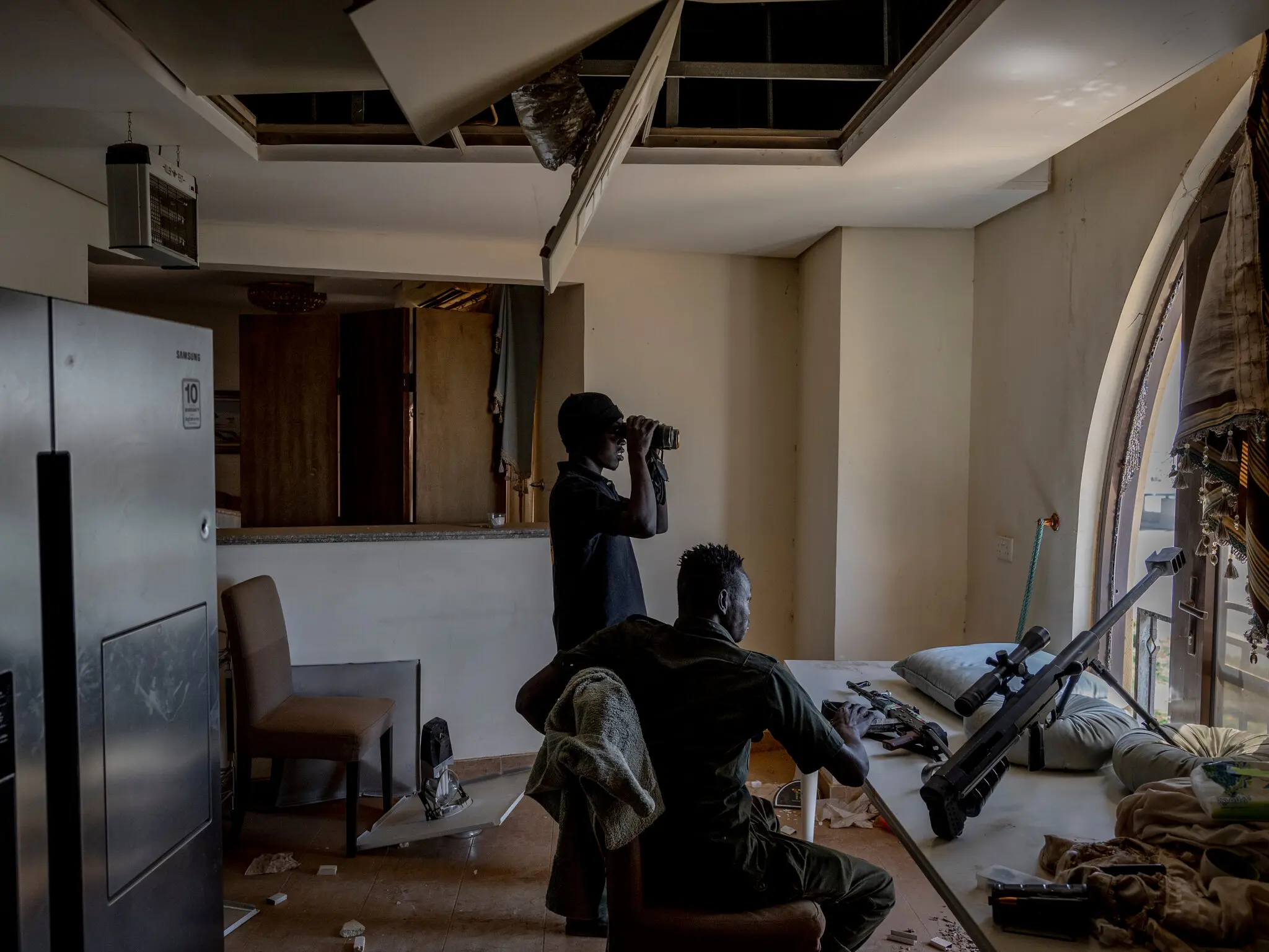 Суданські снайпери спостерігають за позиціями сил швидкої підтримки біля президентського палацу, через річку Ніл, із безлюдної розкішної квартири 12 березня.